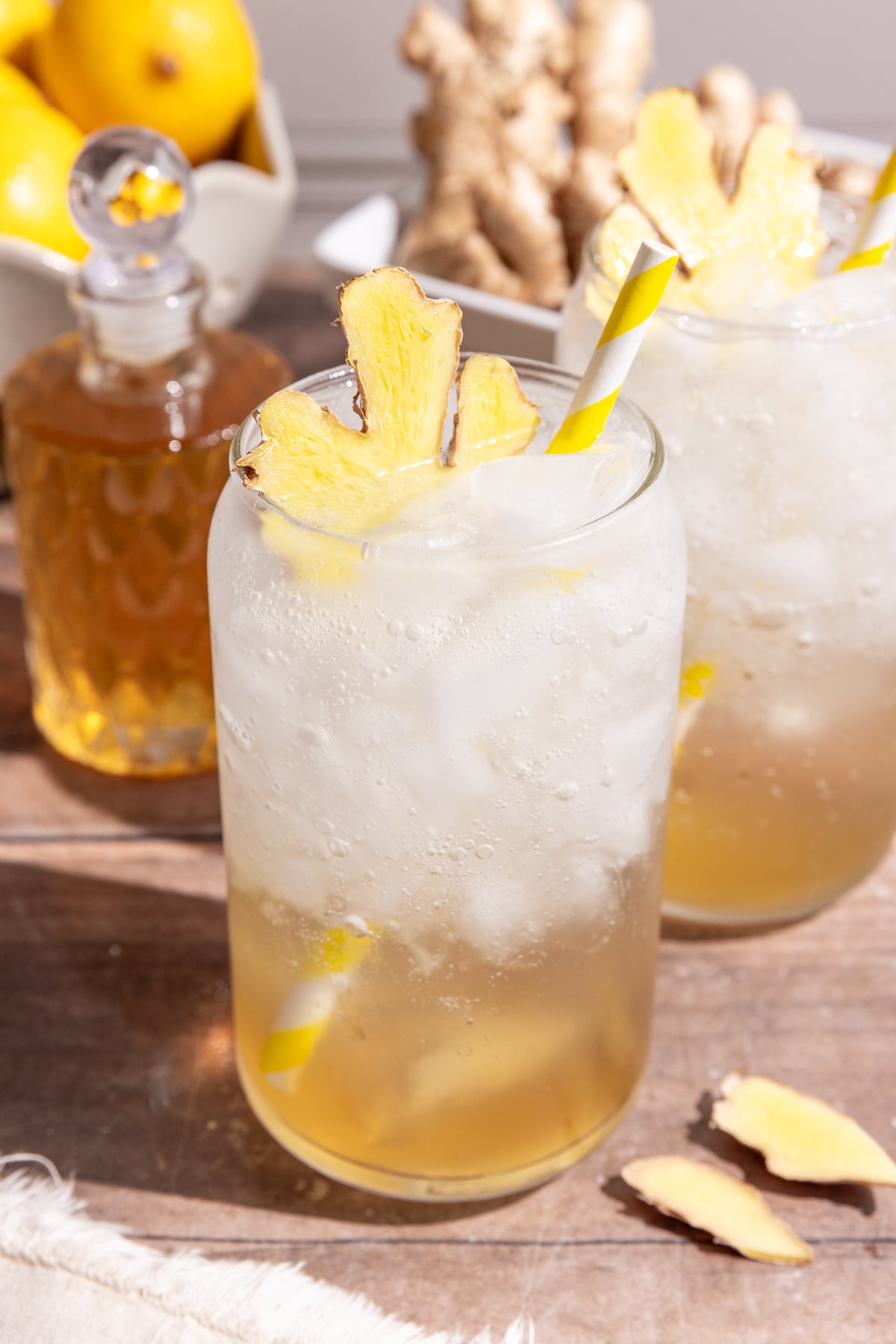 A glass of homemade ginger ale, garnished with a slice of fresh ginger.