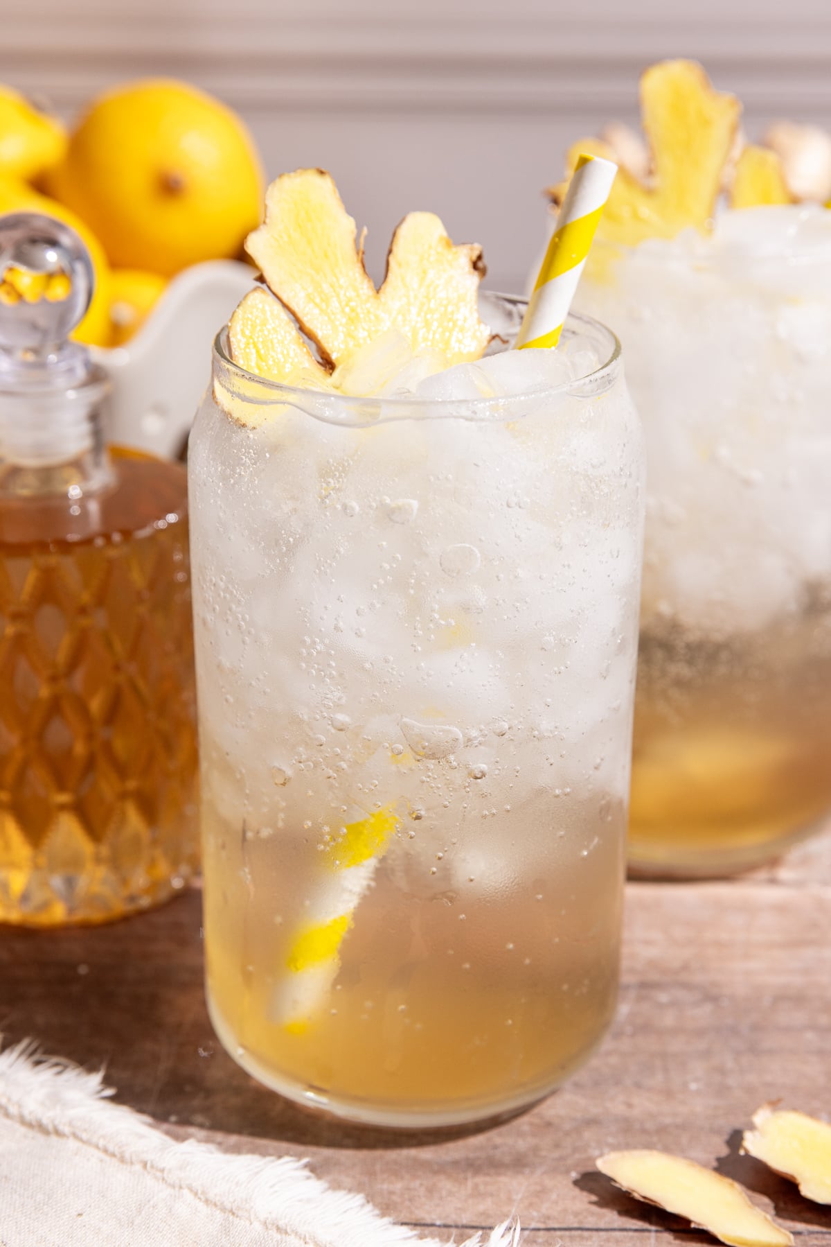 A glass of homemade ginger ale, garnished with a slice of fresh ginger.