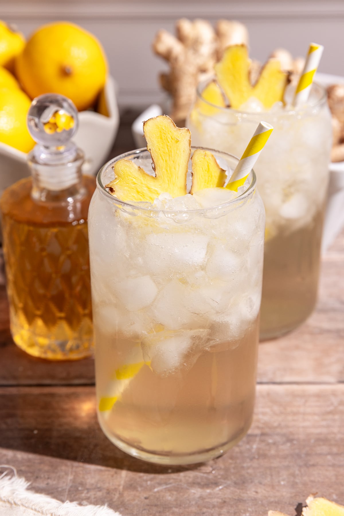 A glass of homemade ginger ale, garnished with a slice of fresh ginger.