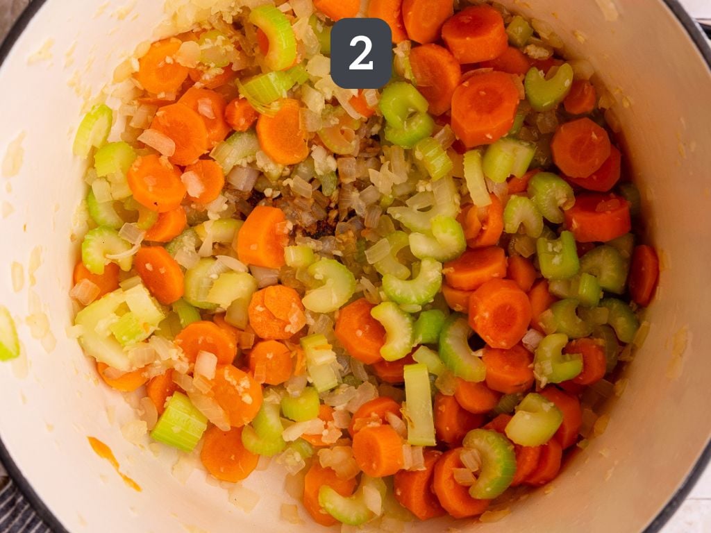 Vegan Creamy Chicken Noodle Soup Step 2 - sauté the onion, carrot, celery, and garlic.